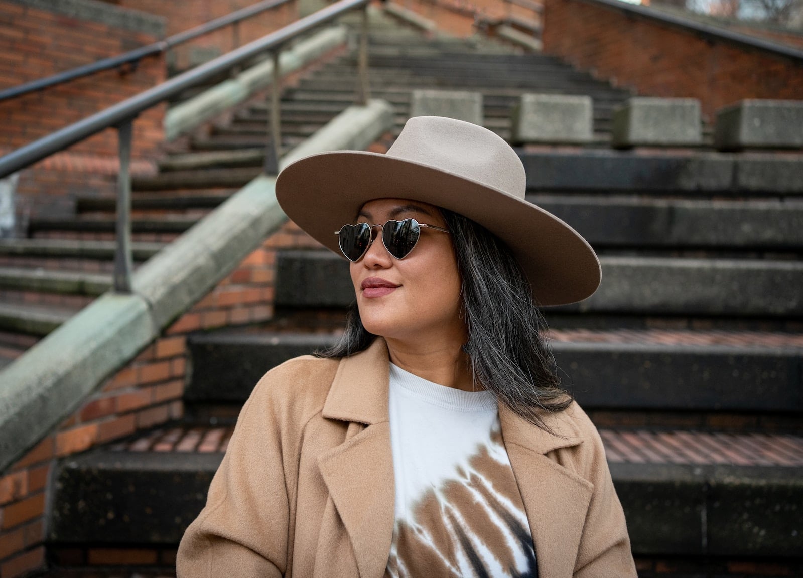 a woman wearing a brown hat and sunglasses